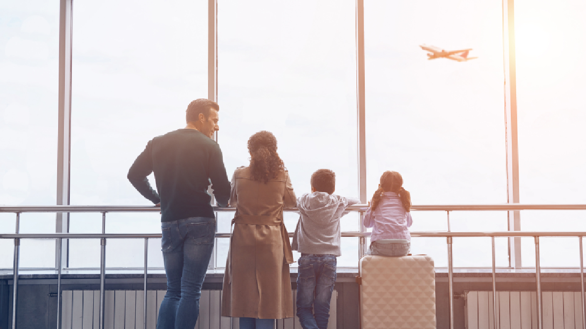 Family relocating abroad with luggage at an airport